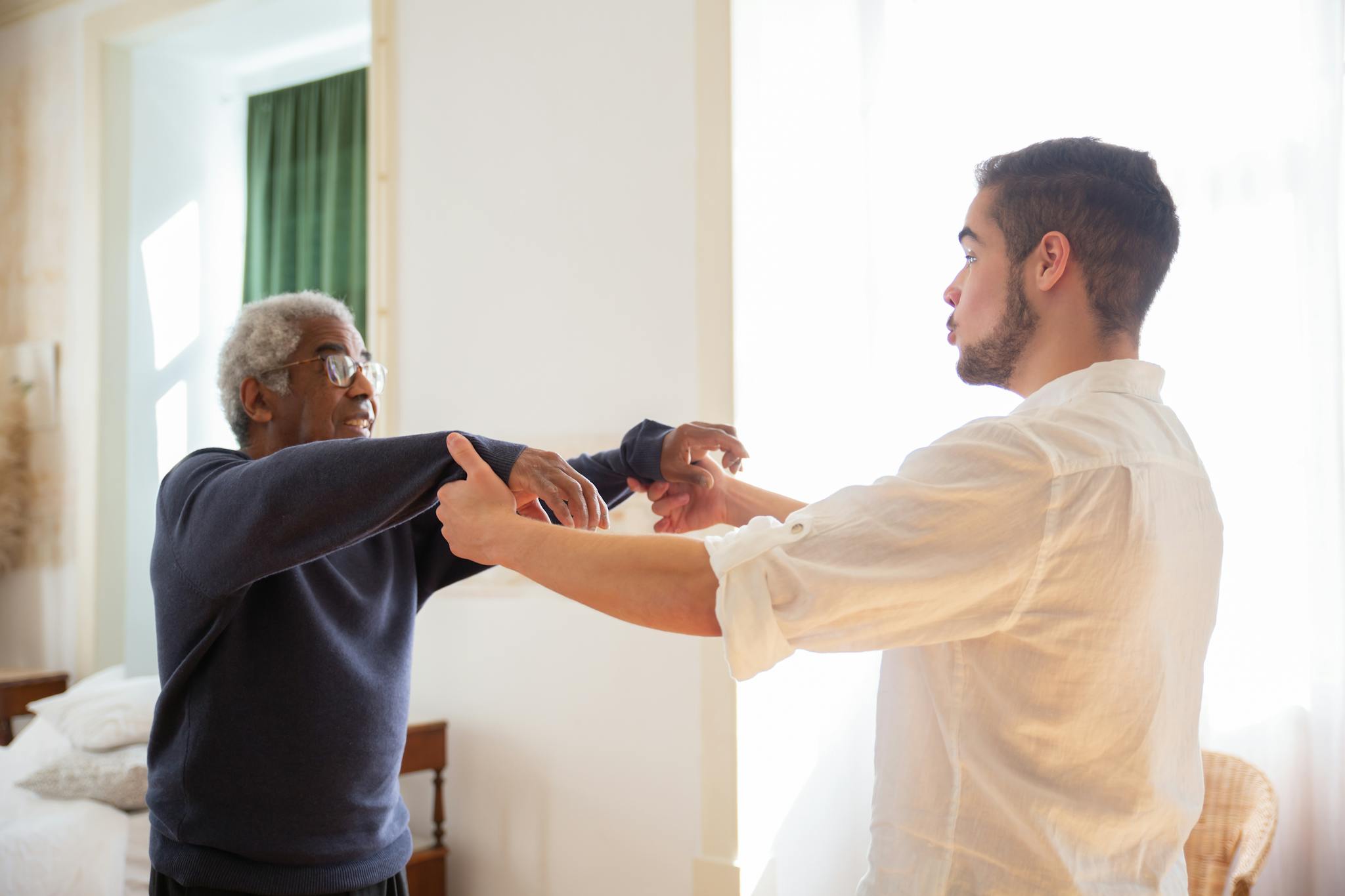 Senior receiving support from caregiver at home, showcasing care and communication.