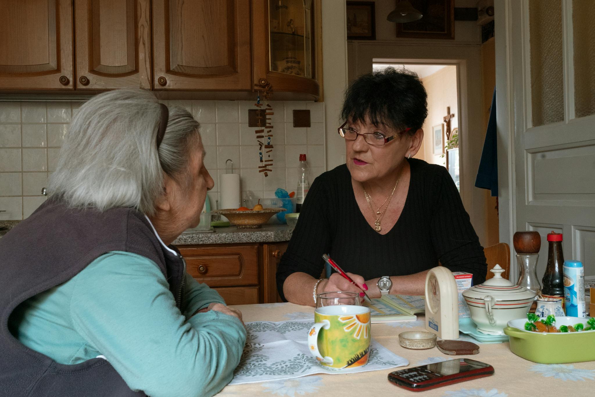 Senior woman and caregiver having a conversation in a cozy kitchen — Newport Home Health Texas