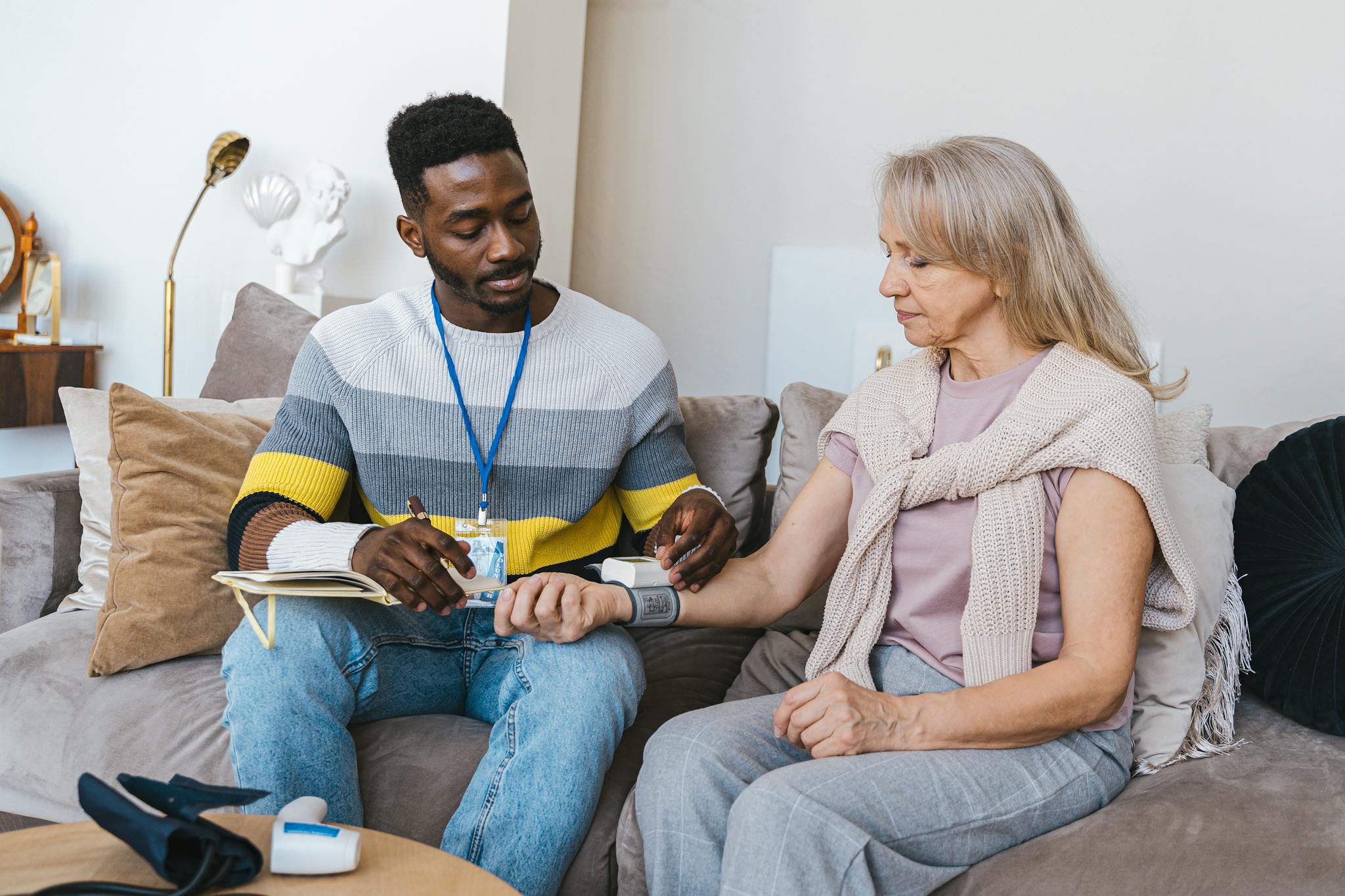 Volunteer checking elderly woman's blood pressure — Newport community program